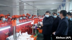 资料照片:中共领导人习近平戴着口罩视察陕西安康一家工厂的生产线。(2020年4月21日)