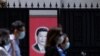 资料照:戴着口罩的上海市民走过内有一幅习近平画像的大门。(2020年5月22日)