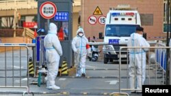 在陕西西安出现新冠病毒疫情反扑后,防疫人员封锁一所大学的学生宿舍区出入口。(2021年12月20日)