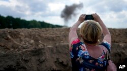 资料照片:一名记者正在拍摄乌克兰扫雷人员清除地雷的场景。(2022年6月9日)