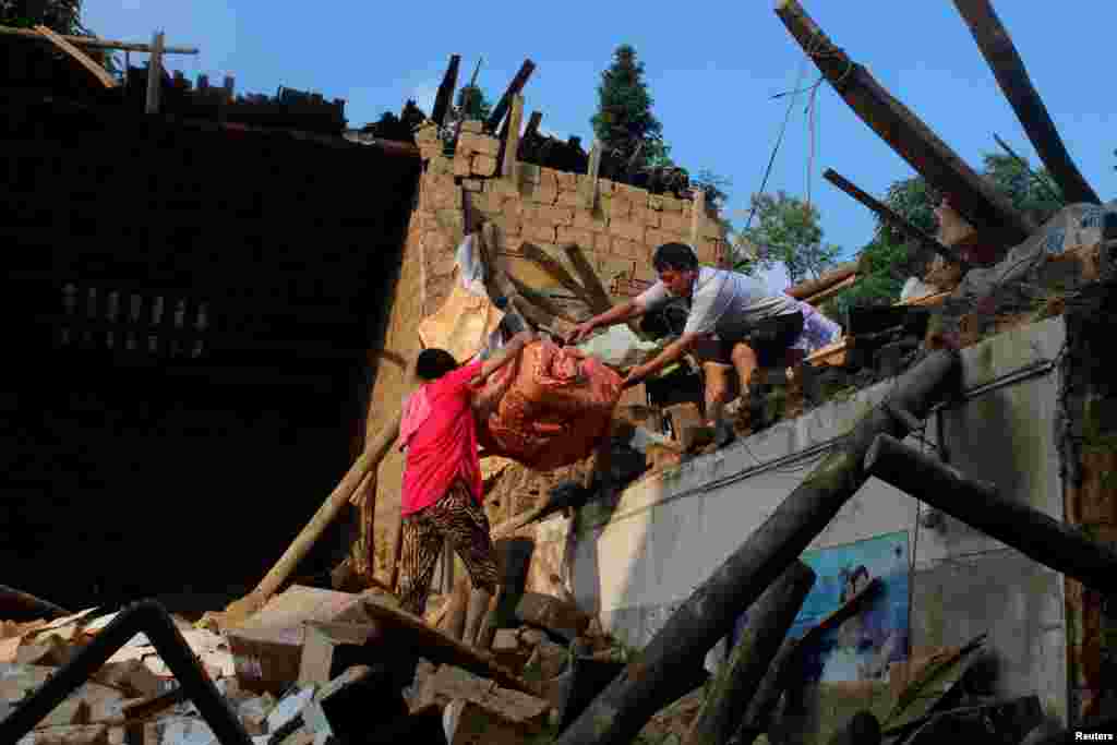 在湖南涟源,暴雨后,灾民从倒塌的房子里搬东西(2017年7月3日)