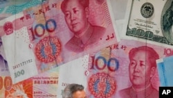 一百元面值的人民币和美元 。(美联社示意图)