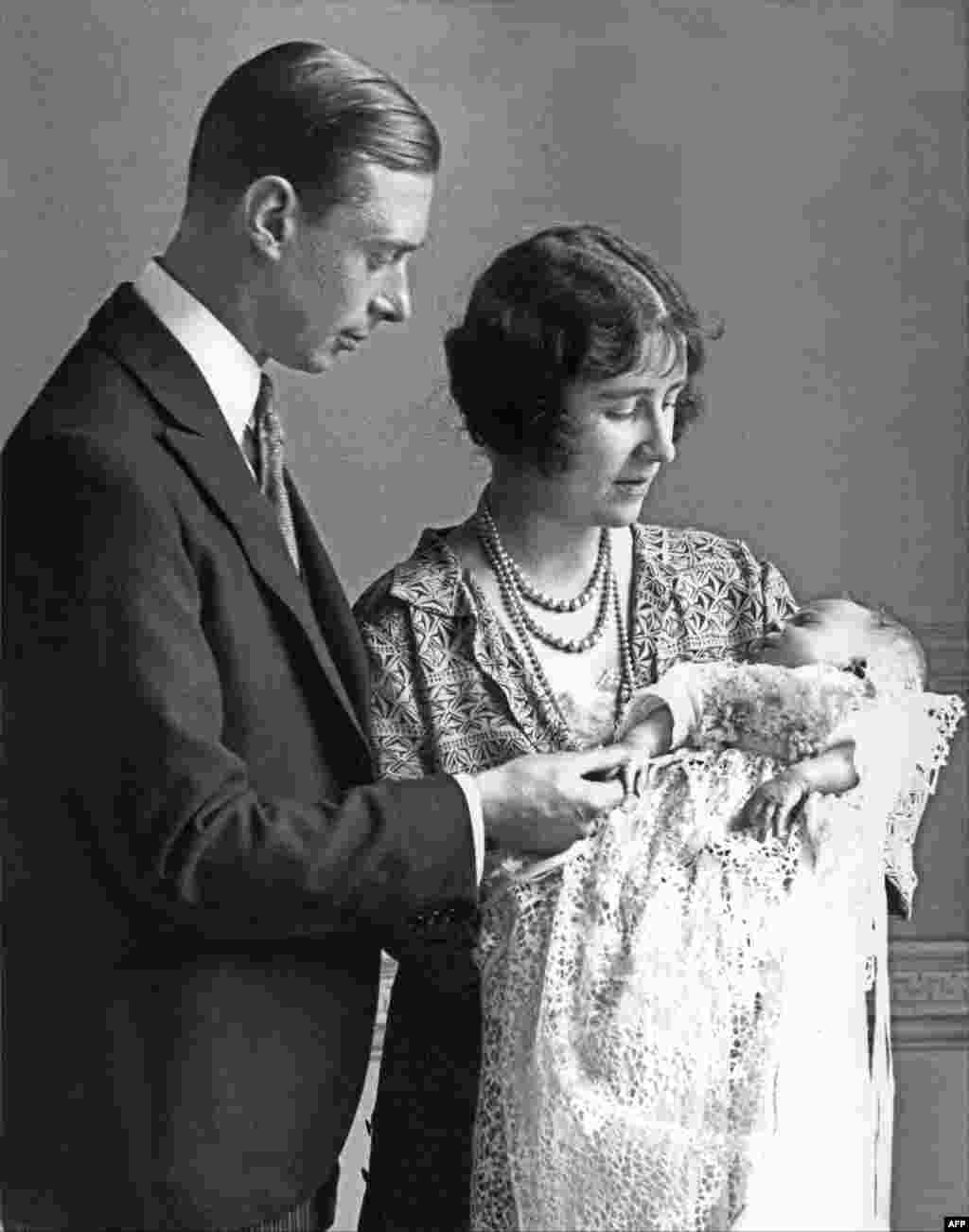 Phu nhân Elizabeth Angela Marguerite Bowes-Lyon, con gái của Bá tước Strathmore thứ 14, Nữ công tước xứ York (phải) bế đứa con đầu lòng của bà, Công chúa Elizabeth, vào năm 1926, bên cạnh chồng bà, Công tước xứ York. Em bé sinh ngày 21 tháng 4.  