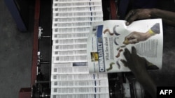 资料照片:肯尼亚首都内罗毕一家印刷厂的技术人员正在检查当地中国人拥有的《中国日报》(2014年1月3日)