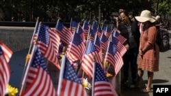 2022年9月10日,在世界贸易中心、五角大楼和宾夕法尼亚州尚克斯维尔袭击事件21周年纪念日的前一天,游客在纽约911纪念馆观看美国国旗。