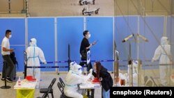 资料照:抵达上海虹桥国际机场的旅客在接受新冠核酸检测。 (2022年10月12日)