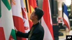 东盟国家联盟(ASEAN)十国外长和中国官员2023年7月10号在印度尼西亚首都雅加达举行避免在南中国海地区发生重大武装冲突会议。一位印尼工作人员正在整理国旗。