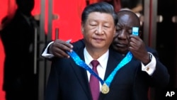 资料照:南非总统西里尔·拉马福萨(Cyril Ramaphosa)在普雷托利亚给到访的中国领导人习近平佩戴一枚勋章。(2023年8月22日)