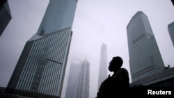 资料照:一名男子站在上海浦东金融区的街道上。