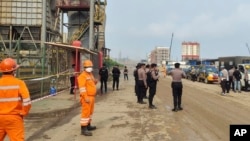 资料照片:印度尼西亚中苏拉威西岛莫罗瓦利的青山不锈钢有限公司冶炼厂发生爆炸后,警察和工人站在现场附近。(2023年12月24日)