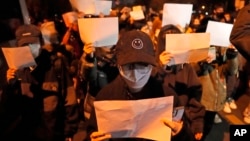 资料照:北京的年轻人手举白纸上街示威。(2022年11月27日)