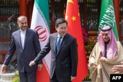 沙特阿拉伯外交大臣费萨尔(右)、伊朗外交部长阿卜杜勒·希扬(左)在北京举行会谈期间与中国外长秦刚(中)在一起。(2023年4月6日)