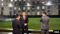 一群香港示威者在伦敦抗议香港经济质易办事处农历新年酒会,一度令中国驻英国大使馆公使杨晓光(图中)一行人在外面等候未有入场。 美国之音记者询问他们是否大使馆的人员后,他们不发一言急步走入伦敦市中心国宴厅会场 (美国之音/郑乐捷)