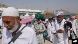 FILE - Muslim pilgrims arrive to cast stones at pillars in the symbolic stoning of the devil, the last rite of the annual hajj, in Mina, near the holy city of Mecca, Saudi Arabia, June 18, 2024.