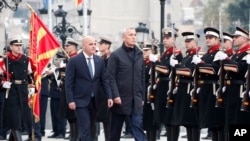 2023年11月21日,北约秘书长斯托尔滕贝格(中)在北马其顿总理科瓦切夫斯基(中左)的陪同下,在北马其顿斯科普里政府大楼检阅仪仗队。(美联社照片)