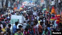 资料照:印度民众在德里旧城区拥挤的商业街购物。(2022年10月11日)