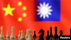 资料图片:国际象棋棋子位于中国和台湾的旗帜前。(2023年4月11日)