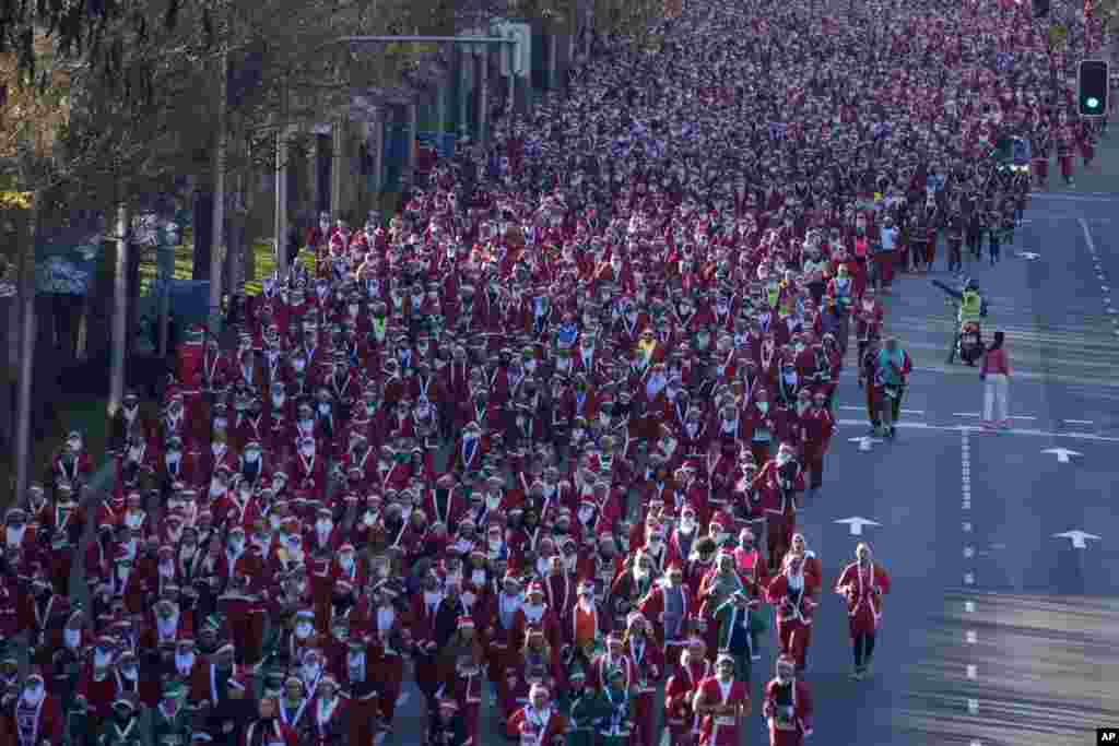 People dressed in Santa Claus costumes take part in a morning run on Christmas Eve in Madrid, Spain, Dec. 24, 2023.