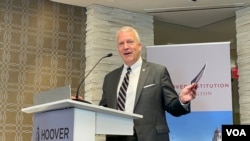 美国国会共和党籍阿拉斯加州联邦参议员丹·沙利文手举《为何台湾重要》手册。(2023年7月18日,美国之音锺辰芳拍摄)