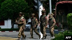资料照片:缅甸军方安全部队人员在仰光静默罢工期间在街头巡逻。(2024年2月1日)