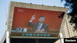 资料照片:北京街头大型电子屏幕播放中共领导人习近平出席中共20届三中全会的电视图像。(2024年7月18日)
