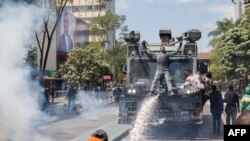 在肯尼亚首都内罗毕的市中心,抗议者登上警方的水炮车。(2024年6月25日)