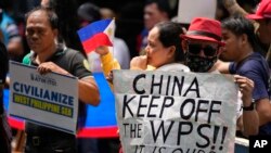 菲律宾渔民和活动人士在中国驻马卡蒂领事馆前举牌抗议中国海警执法新规。(2024年6月11日)