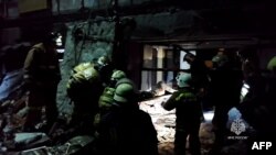 This grab from a video released by the Russian Emergencies Ministry on Feb. 3, 2024, shows rescuers clearing rubble, taking out victims' bodies and searching for survivors inside a destroyed bakehouse hit by recent shelling in the city of Lysychansk.