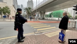 押送黎智英到西九龙裁判法院应讯的囚车，即将驶入法院大楼入口时，大批警员在附近的行人过口处拉起封锁线禁止行人横过马路 (美国之音/汤惠芸)