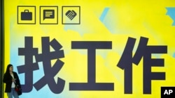 一名女子站在北京一个地铁站张贴的“找工作”的广告牌前。(2024年7月2日)