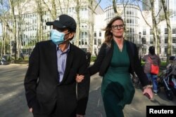 一名美国律师陪着纽约华裔居民卢建旺(译音:Lu Jianwang)走出布鲁克林联邦法庭。(2023年4月17日)