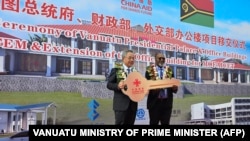 瓦努阿图总理办公室2024年7月2日发布图片显示,中国全国政协副主席胡春华在瓦努阿图新总统府正式移交给瓦努阿图政府的仪式上向瓦努阿图总理萨尔瓦伊(右)递交钥匙。