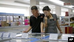 一对夫妇在朝鲜平壤的一家百货商店浏览冷冻食品区。(资料照片,2017年6月19日)