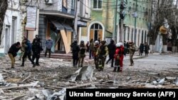 This handout photo taken and released by Ukrainian Emergency Service on Feb. 2, 2024, shows rescuers working outside a building damaged after an air strike on Kherson, Ukraine. (Ukrainian Emergency Service via AFP) 