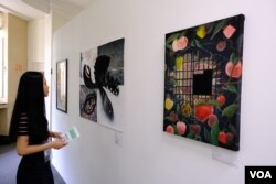 参展者“煲儿”其中一幅显示被封禁的苹果,但在铁闸以后,却生出不少新的苹果 (美国之音/郑乐捷)