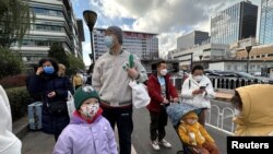 资料照片:北京一家儿童医院外排队等候看病的儿童和家长。(2023年11月27日)