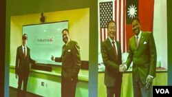 华府玉山科技协会展示富士康创办人郭台铭(左)与美国马里兰州立大学校长达瑞尔·派恩斯签订工业人工智能合作备忘录照片。(2023年3月28日,美国之音锺辰芳拍摄)