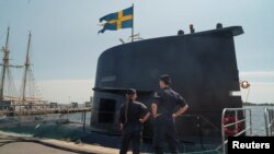 2023年5月25日,水手们站在瑞典潜艇“哥特兰号”前,该潜艇停泊在瑞典卡尔斯克鲁纳海军基地的一个港口。(路透社照片)