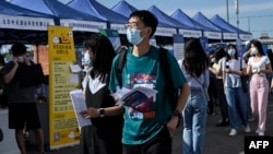 资料照:青年人正在北京的一个招聘点寻找工作。(2022年8月26日)