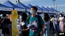 资料照:中国年轻人在北京的一个招聘会上寻找工作。(2022年8月26日)