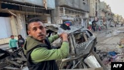 2024年4月10日,哈马斯领导人伊斯梅尔·哈尼耶的三个儿子据报道在以色列对加沙城以西的沙蒂营地的空袭中丧生。图为一名男子手指哈尼耶的三个儿子被炸死时乘坐的汽车。(法新社照片)