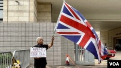 香港民主派初选47人被控国安法下串谋颠覆国家政权案,11月29日开始口头结案陈词,社运人士王婆婆在西九龙裁判法院示威区内,独自一人手持英国旗及标语,要求释放47、释放所有政治犯 (美国之音/汤惠芸)