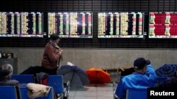资料照:上海一家股票交易所里投资人正在观看电子屏幕显示的股市动态。(2020年1月16日)