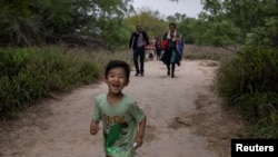 资料照片:一名5岁来自中国的男童和他的家人渡过美墨边境的格兰德河走在美国德克萨斯州的道路上。(2023年4月5日)
