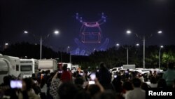 People watch drones' formation flying at the World Drone Light Show 2024, which is a part of the 2024 Korea Drone Expo, in Incheon, South Korea, May 9, 2024.