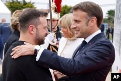 法国总统马克龙在法国奥马哈海滩欢迎乌克兰总统泽连斯基出席诺曼底登陆80周年纪念活动。(2024年6月6日)