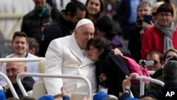 2023年3月29日,教宗方济各在梵蒂冈圣彼得广场的每周公开接见结束时拥抱一个孩子。(美联社照片)