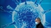 一名男子走过英国一家研究生物病毒的科研中心外的广告墙。(2020年8月3日)