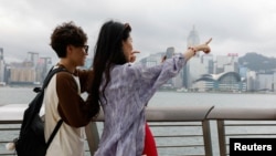 两名中国年轻人五一节前到香港游玩时在小红书上寻找旅游攻略。(2024年4月30日)