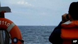 2023年8月19日,台湾国防部发布的视频截图,一名台湾海军水手在成功级巡防舰“田单号”上在台湾沿海监视中国海军舰艇“徐州舰”。(美联社照片)